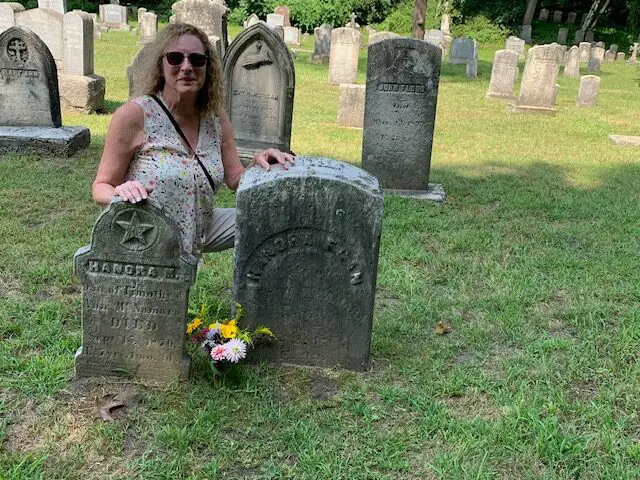 Sean next to the grave of her ancestor, Honora Egan in a Vermont gravesite